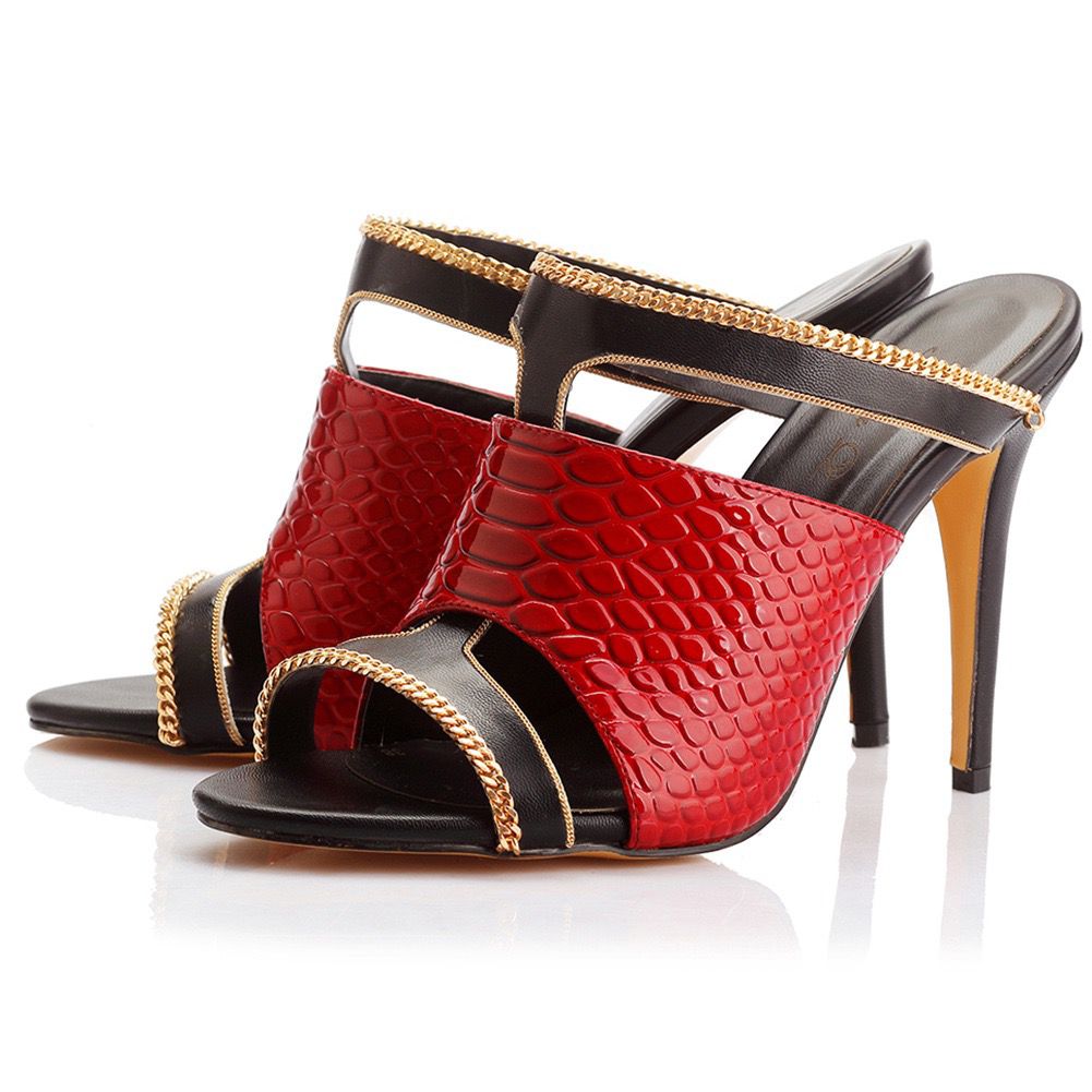 Red high-heeled shoe with black and gold accents on a white background